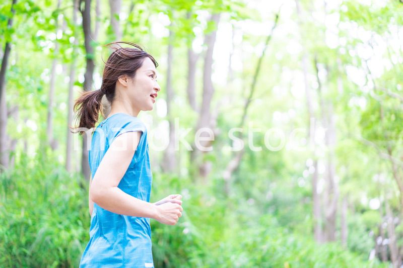 自然の中でランニングをする若い女性