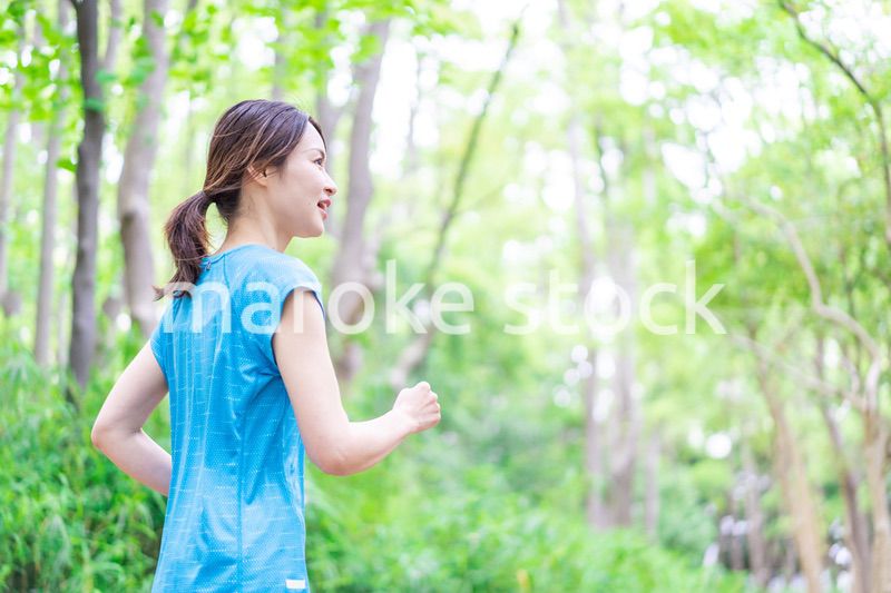 自然の中でランニングをする若い女性