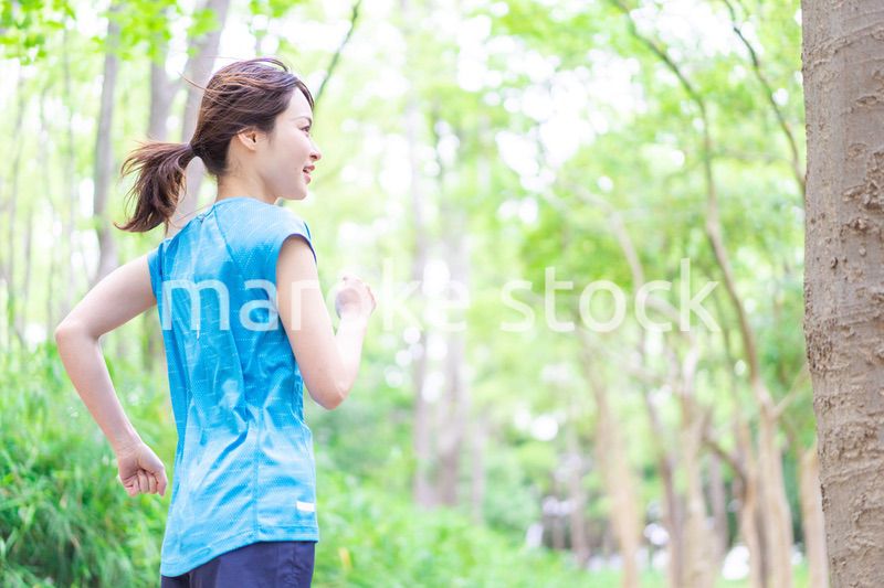自然の中でランニングをする若い女性