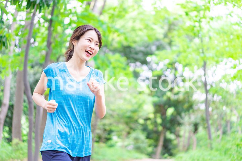 自然の中でランニングをする若い女性