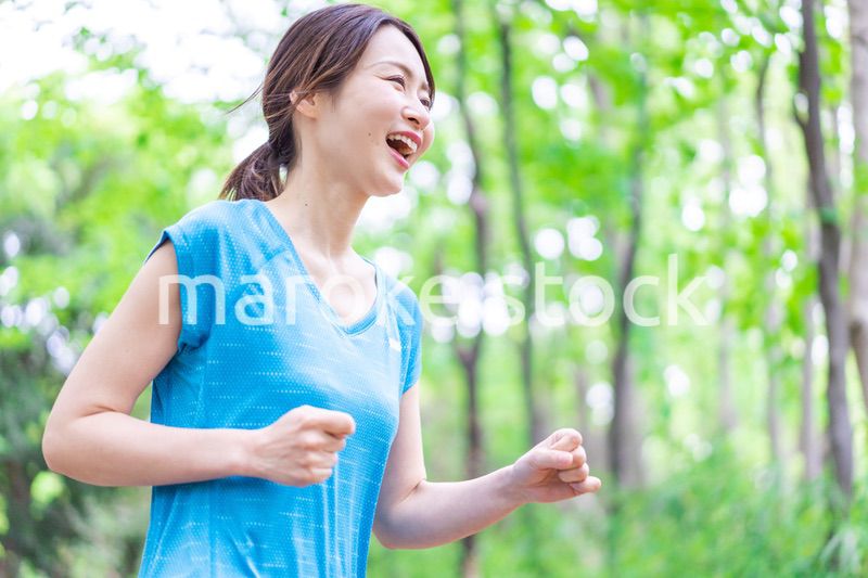 自然の中でランニングをする若い女性