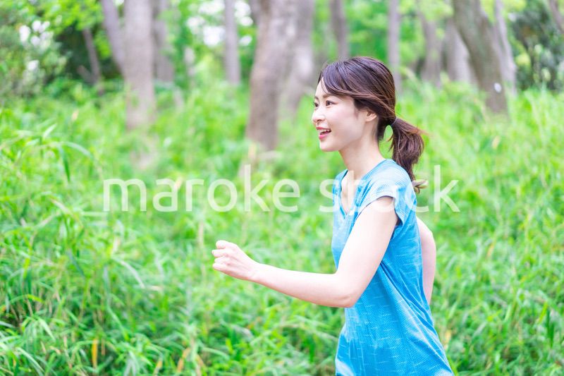 自然の中でランニングをする若い女性
