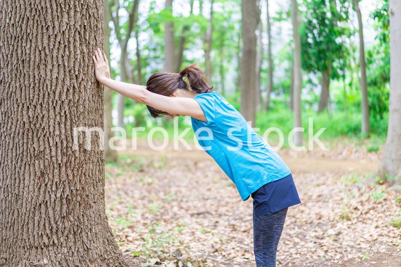 自然の中でストレッチをする若い女性