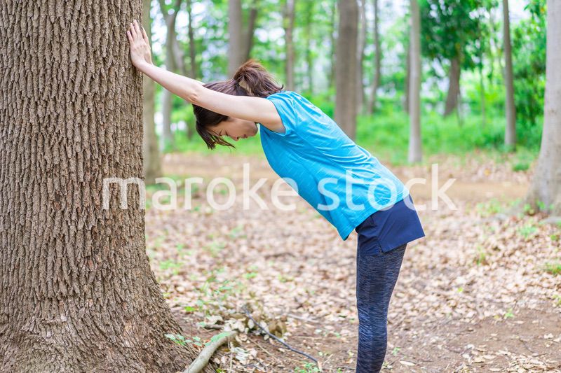 自然の中でストレッチをする若い女性