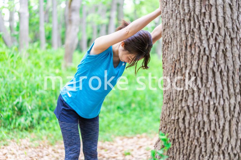 自然の中でストレッチをする若い女性