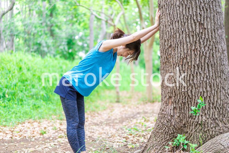 自然の中でストレッチをする若い女性