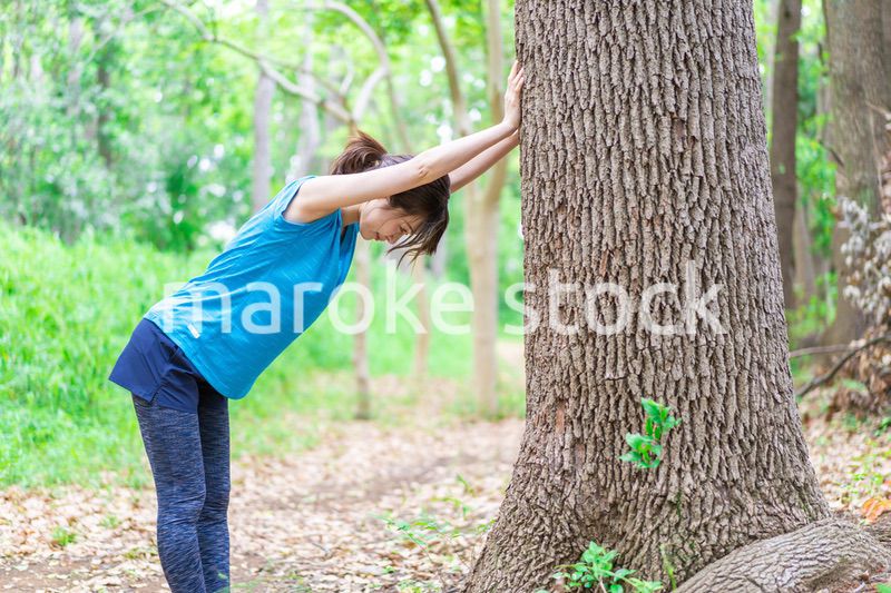 自然の中でストレッチをする若い女性
