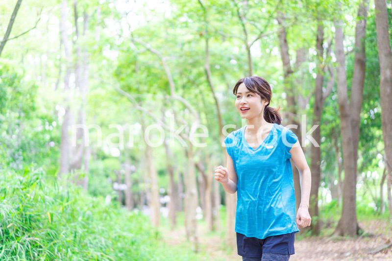 自然の中でランニングをする若い女性