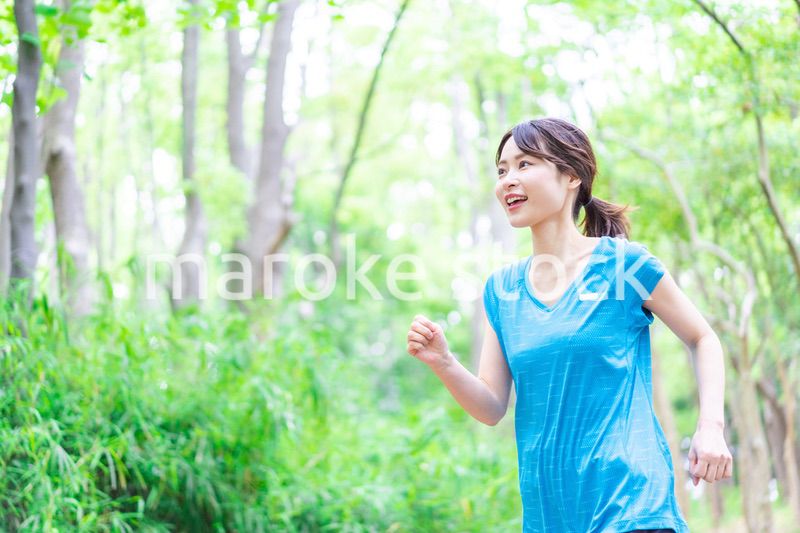 自然の中でランニングをする若い女性