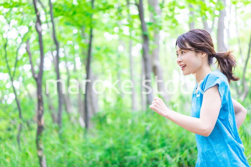 自然の中でランニングをする若い女性