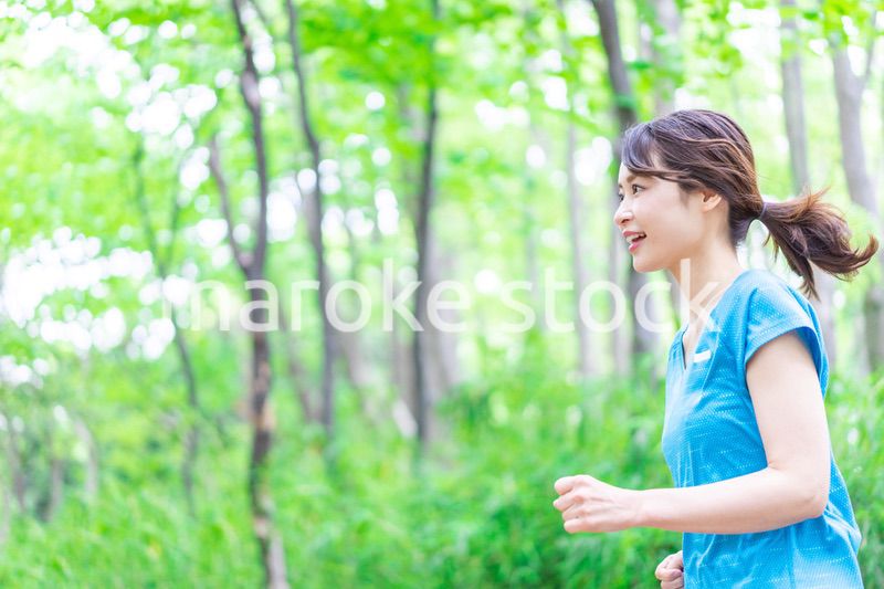 自然の中でランニングをする若い女性