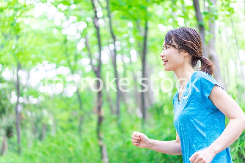 自然の中でランニングをする若い女性