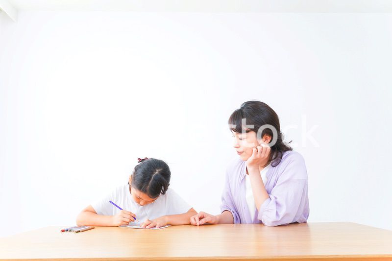 お家でお母さんとお勉強する女の子