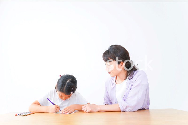 お家でお母さんとお勉強する女の子