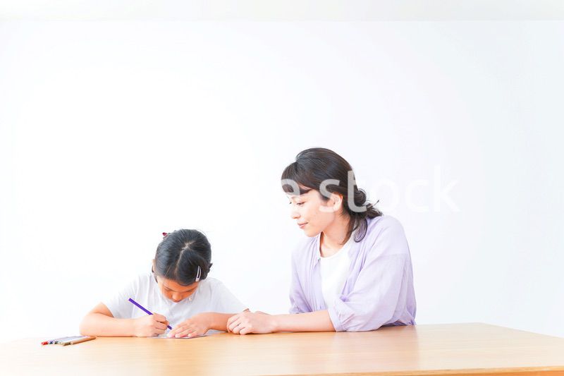 お家でお母さんとお勉強する女の子