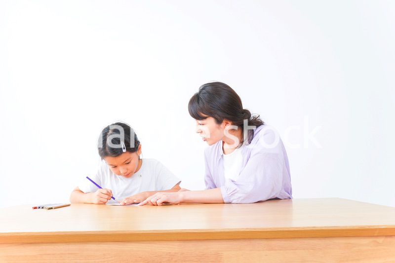 お家でお母さんとお勉強する女の子