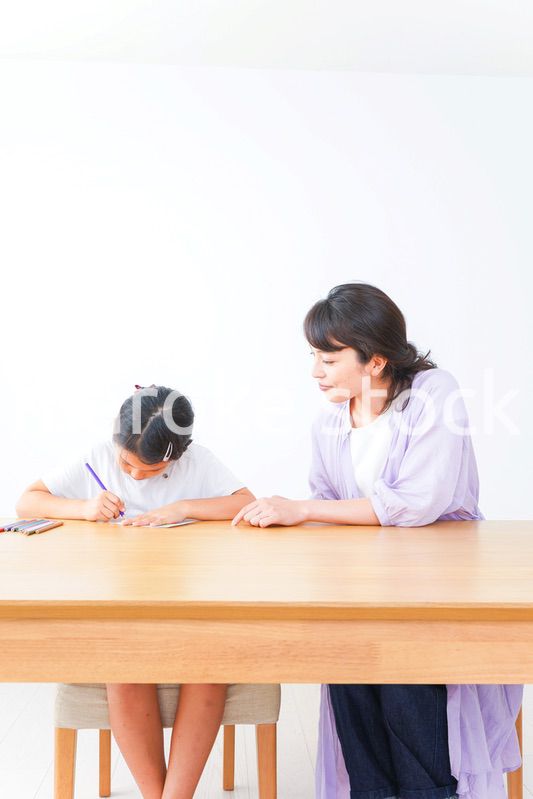 お家でお母さんとお勉強する女の子