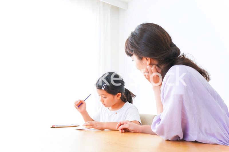 お家でお母さんとお勉強する女の子