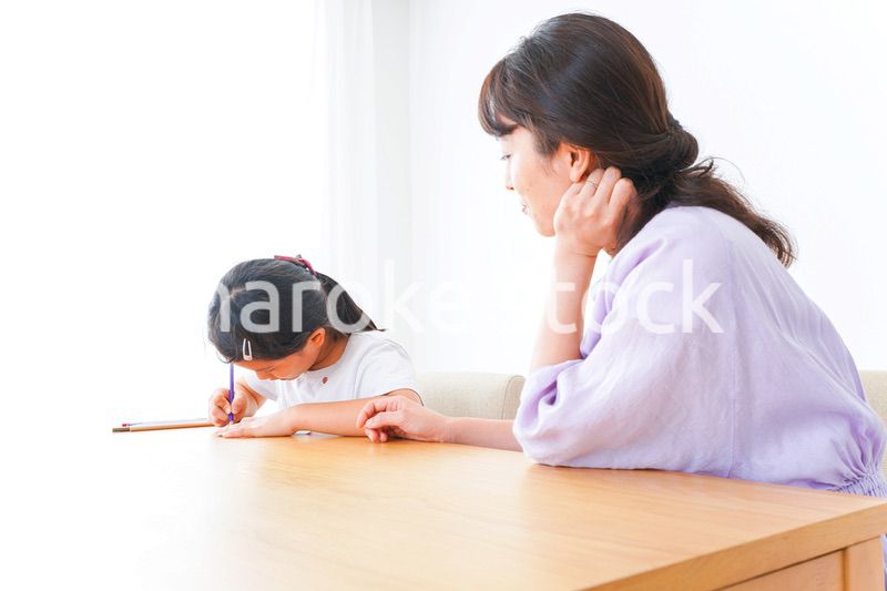 お家でお母さんとお勉強する女の子