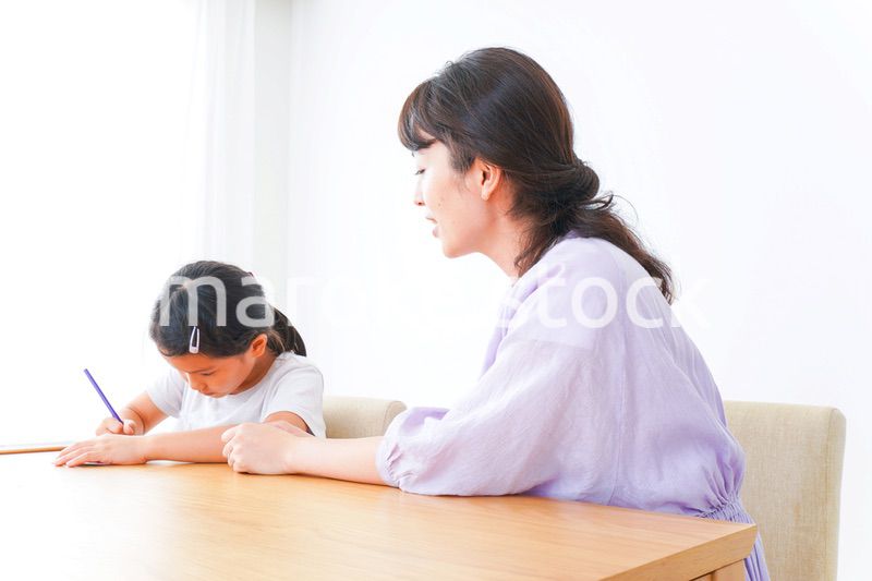お家でお母さんとお勉強する女の子