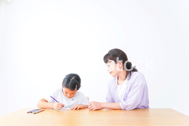 お家でお母さんとお勉強する女の子