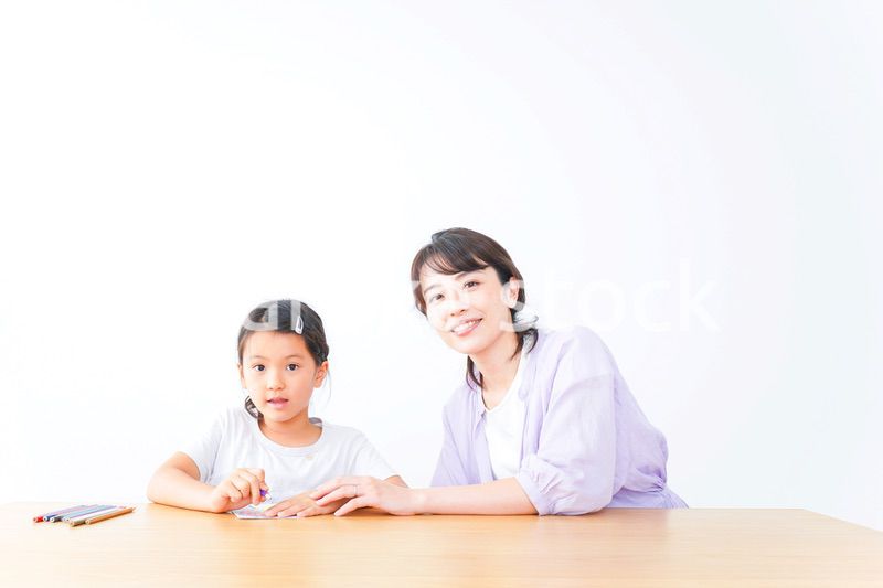 お家でお母さんとお勉強する女の子