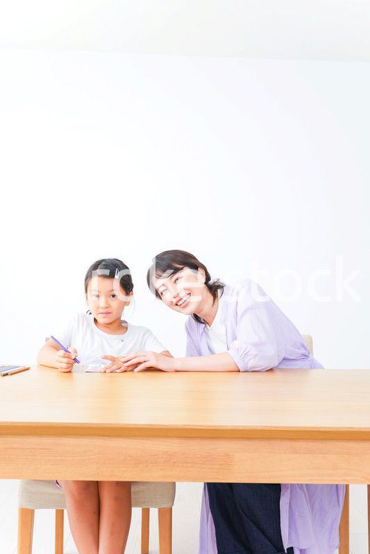 お家でお母さんとお勉強する女の子