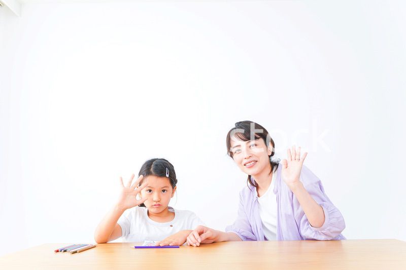 お家でお母さんとお勉強する女の子