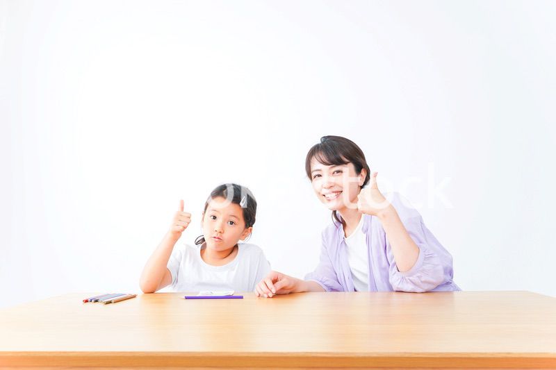 お家でお母さんとお勉強する女の子