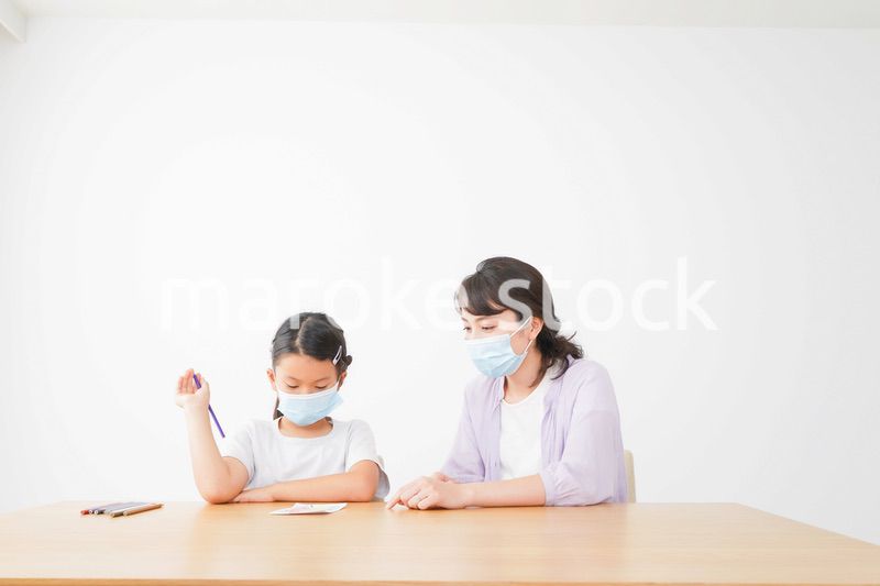 マスクをして小学生に個別指導をする先生