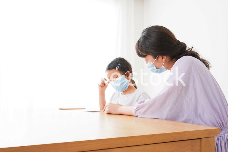 マスクをして小学生に個別指導をする先生