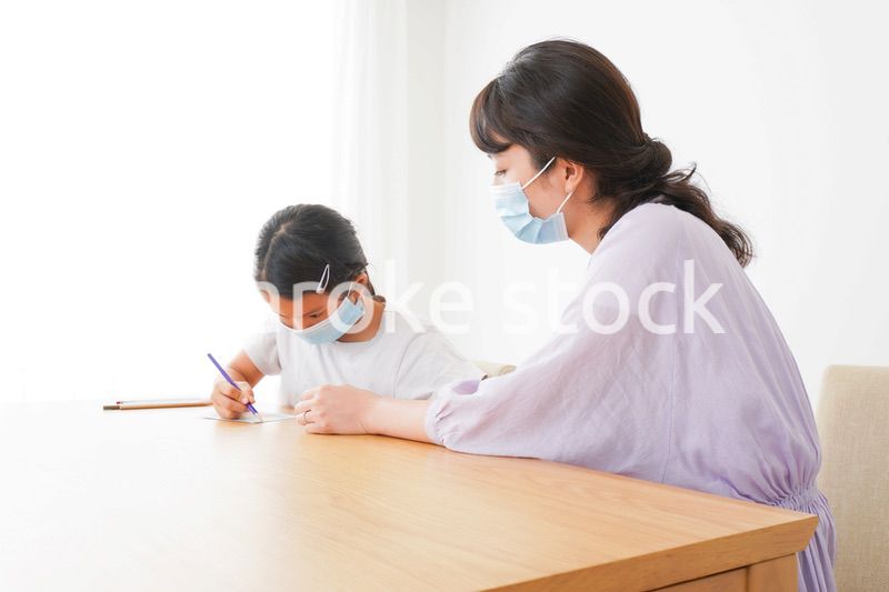 マスクをして小学生に個別指導をする先生