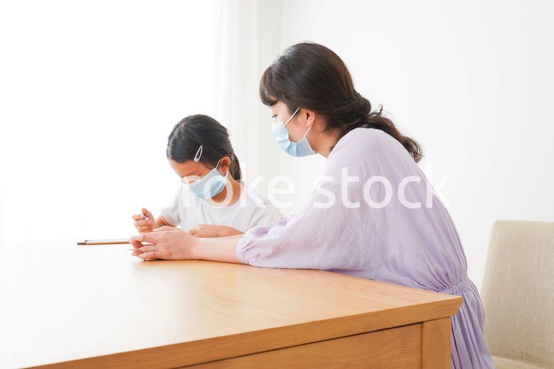 マスクをして小学生に個別指導をする先生