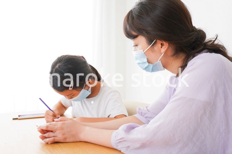 マスクをして小学生に個別指導をする先生