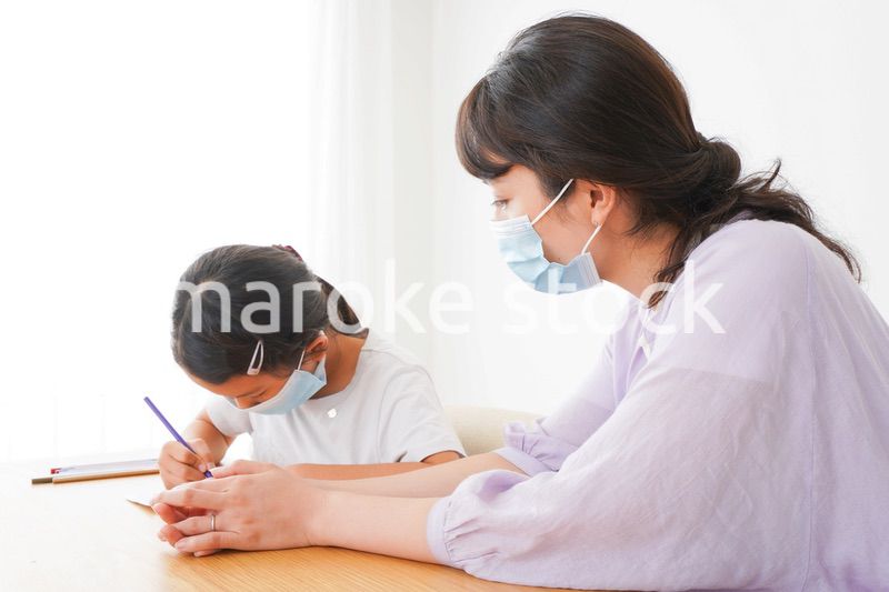 マスクをして小学生に個別指導をする先生