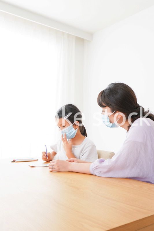 マスクをして小学生に個別指導をする先生