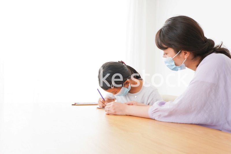 マスクをして小学生に個別指導をする先生