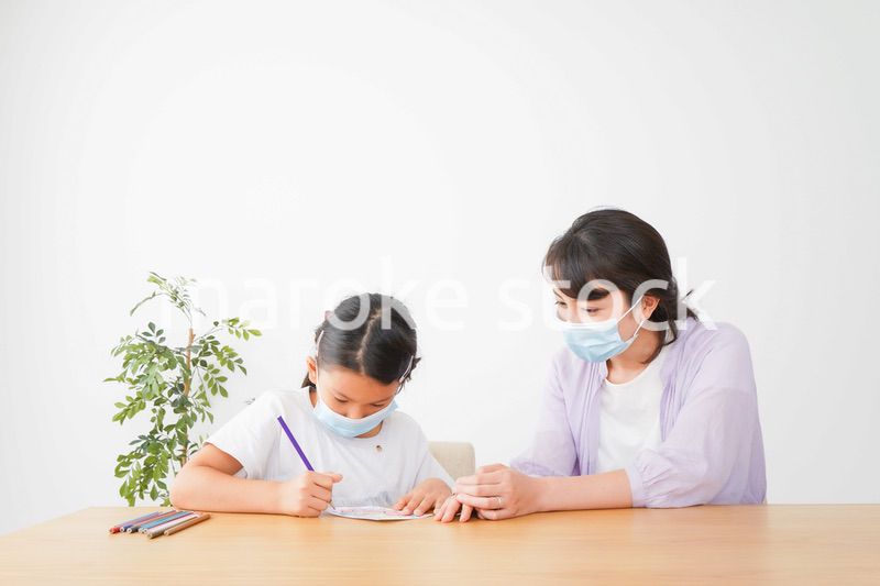 マスクをして小学生に個別指導をする先生