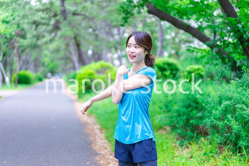 自然の中でストレッチをする若い女性