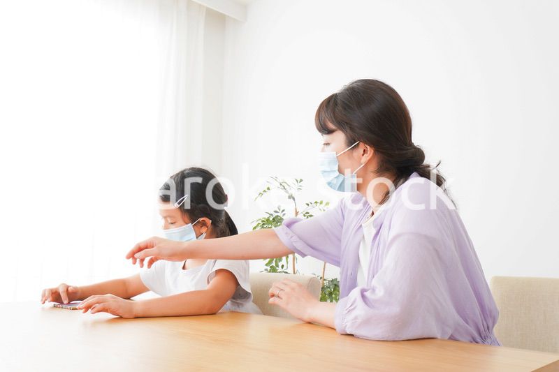 マスクをして小学生に個別指導をする先生