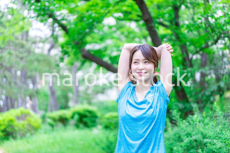 自然の中でストレッチをする若い女性
