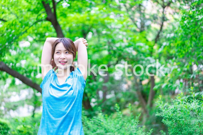 自然の中でストレッチをする若い女性