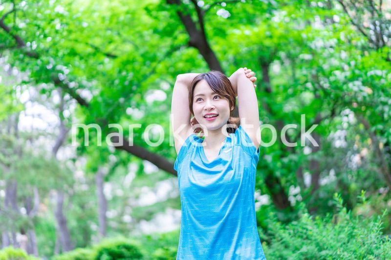 自然の中でストレッチをする若い女性