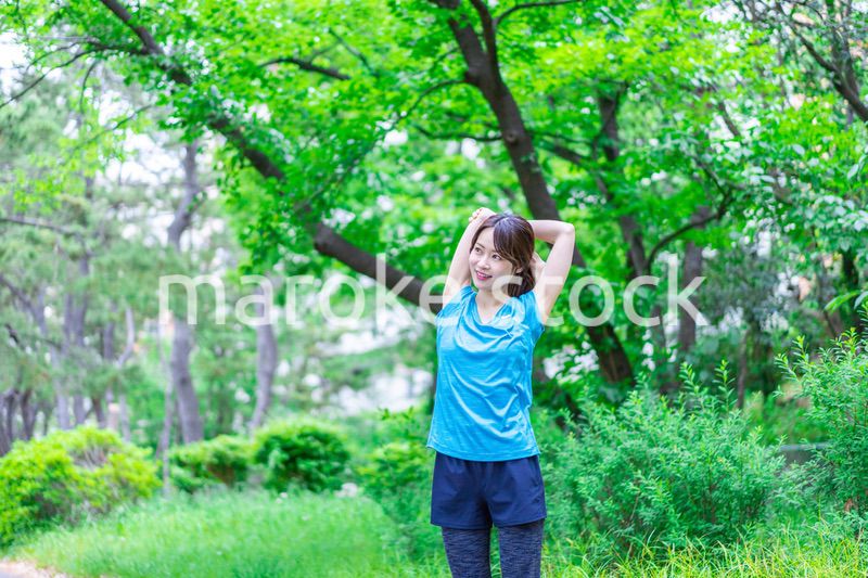自然の中でストレッチをする若い女性