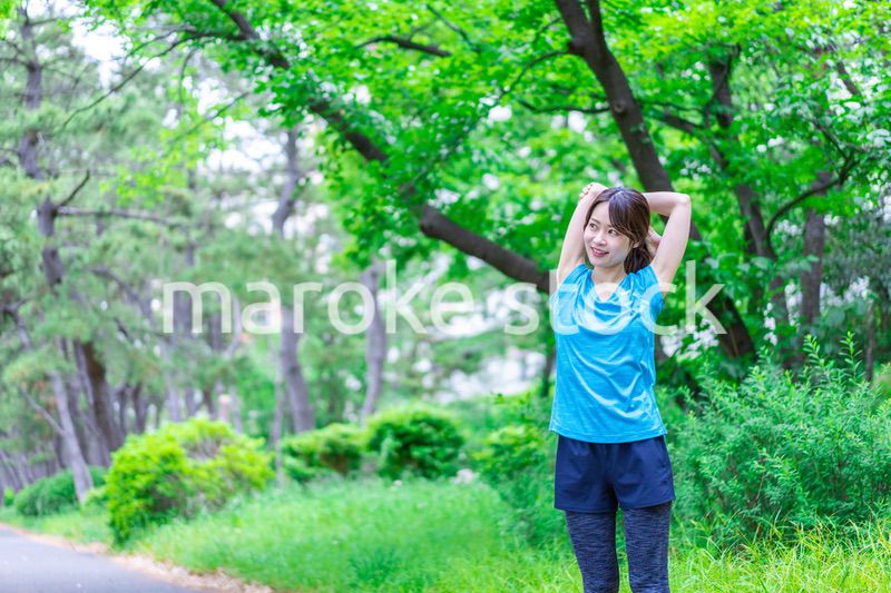 自然の中でストレッチをする若い女性