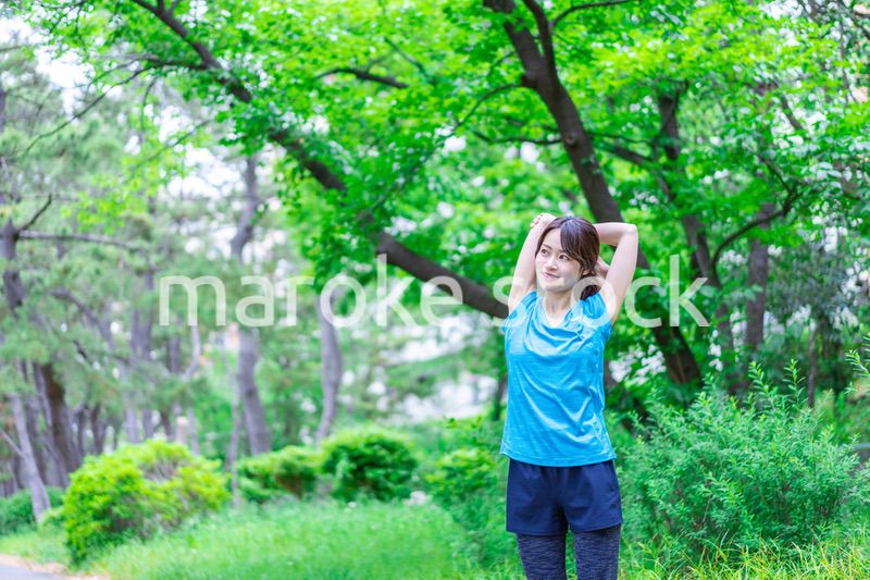 自然の中でストレッチをする若い女性
