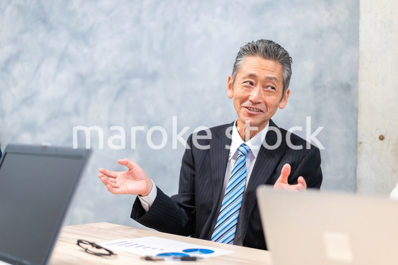 スーツで意見を述べる経営者