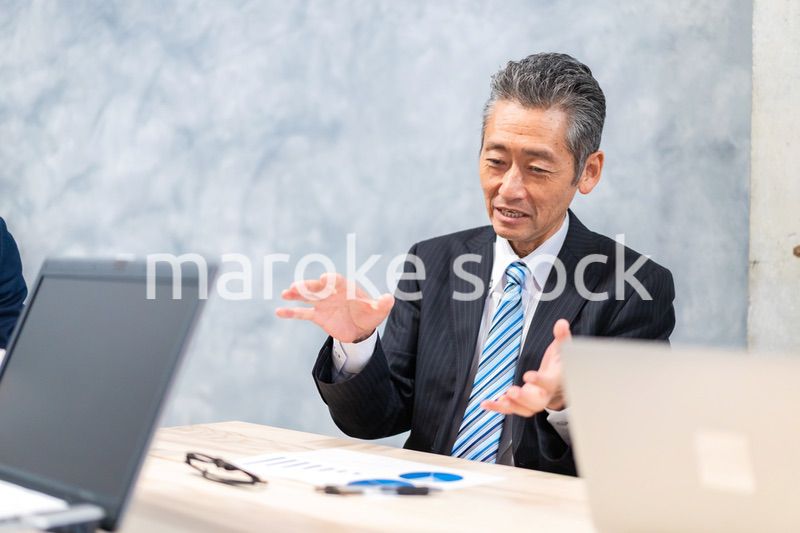 スーツで意見を述べる経営者