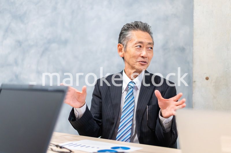 スーツで意見を述べる経営者