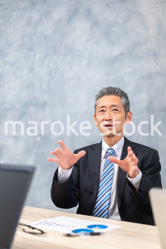 スーツで意見を述べる経営者